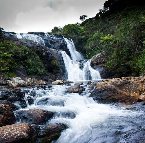 Baker's Falls cascading over dark rock into a boulder-strewn stream at Horton Plains National Park, Sri Lanka